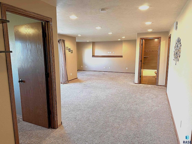 empty room featuring a textured ceiling and light carpet