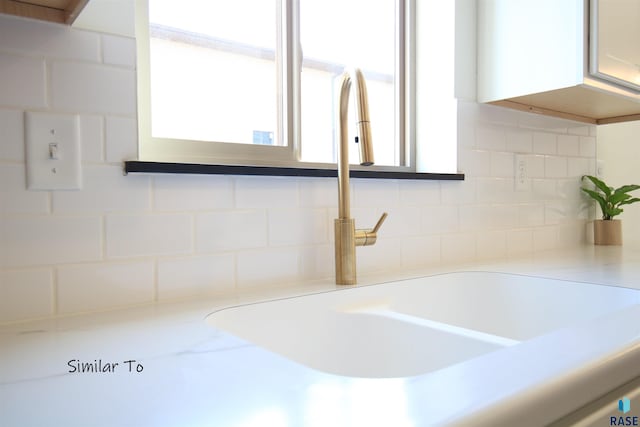 room details with sink, white cabinets, and tasteful backsplash