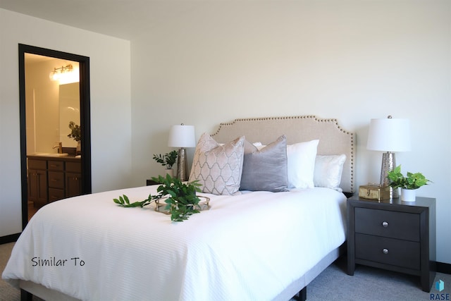 carpeted bedroom featuring ensuite bathroom and sink