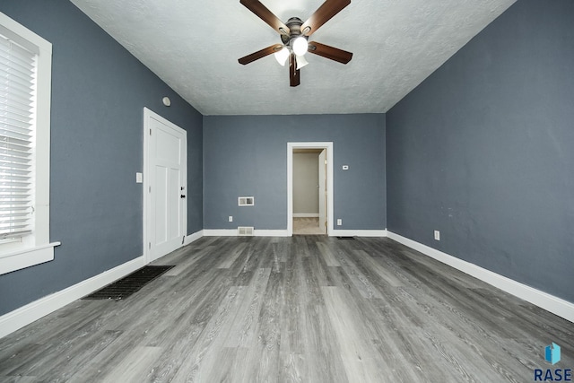 unfurnished living room with a textured ceiling, ceiling fan, and hardwood / wood-style floors