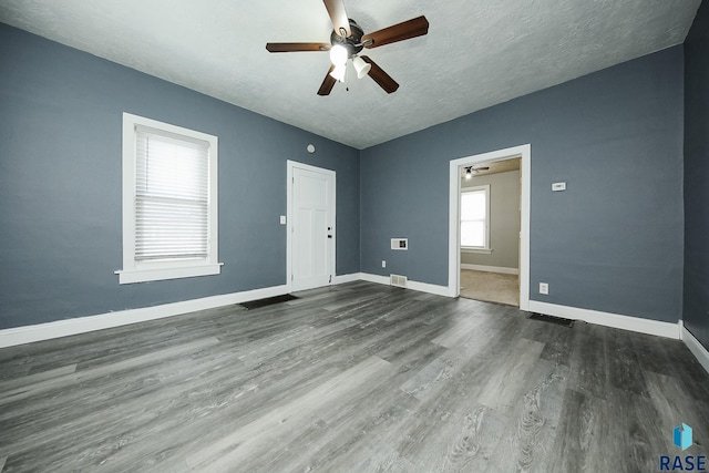 unfurnished room with dark wood-type flooring and a textured ceiling