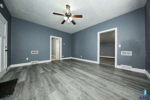 interior space featuring ensuite bath, a textured ceiling, ceiling fan, and dark wood-type flooring