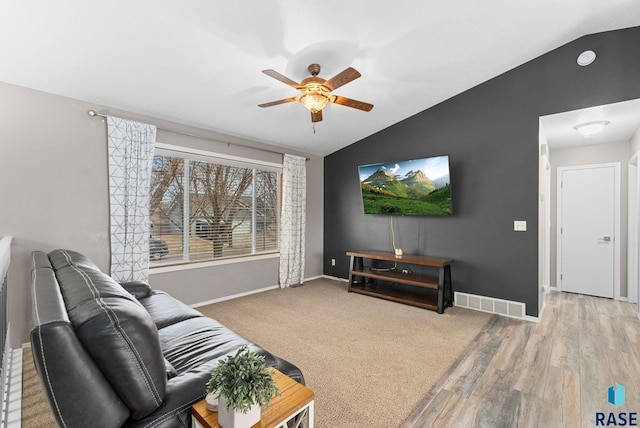 living room featuring ceiling fan, vaulted ceiling, and light hardwood / wood-style flooring