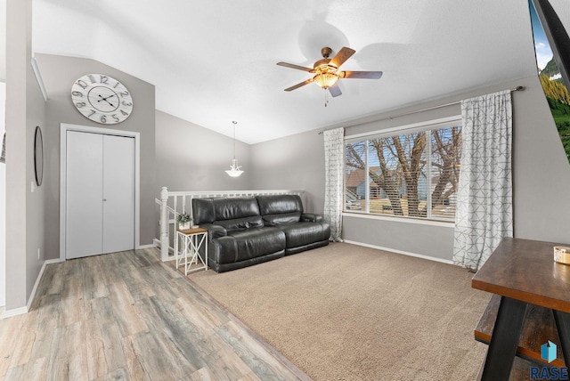 living room with ceiling fan, vaulted ceiling, and wood-type flooring