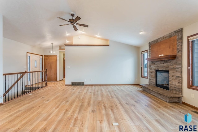 unfurnished living room with vaulted ceiling, a fireplace, ceiling fan, and light hardwood / wood-style floors