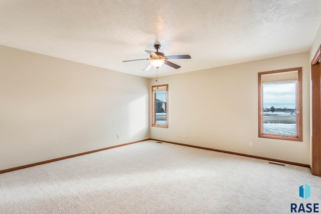 spare room with ceiling fan and carpet