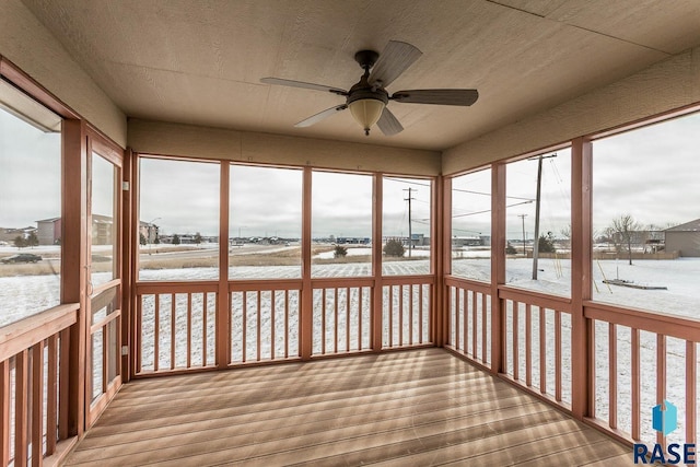 unfurnished sunroom featuring ceiling fan