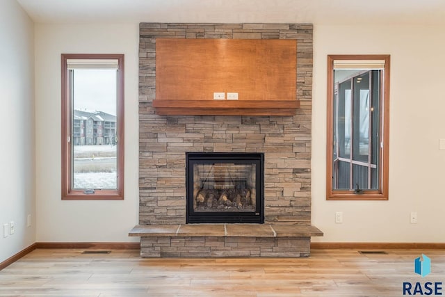 interior details featuring wood-type flooring and a stone fireplace