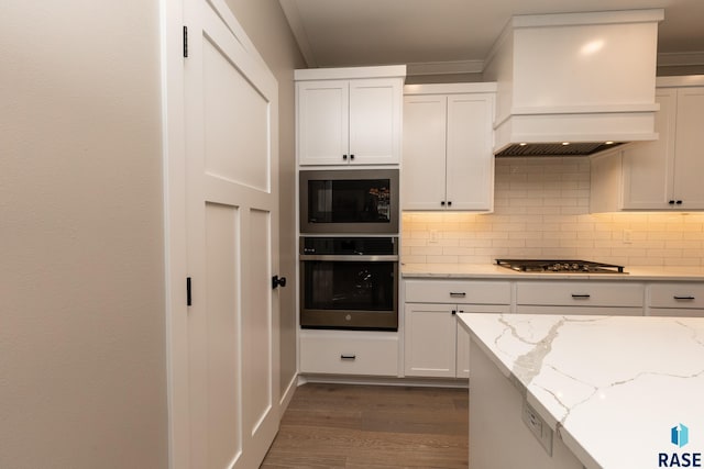 kitchen featuring custom exhaust hood, stainless steel appliances, backsplash, dark hardwood / wood-style flooring, and white cabinets