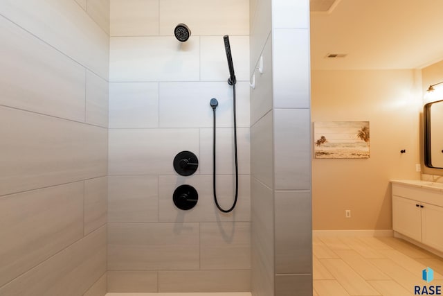 bathroom featuring a tile shower and vanity