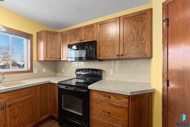 kitchen with sink, backsplash, black appliances, and a textured ceiling