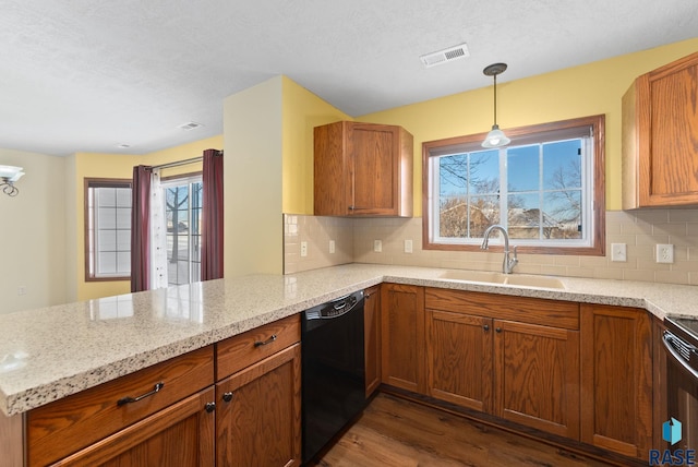 kitchen featuring kitchen peninsula, dishwasher, light stone countertops, pendant lighting, and sink