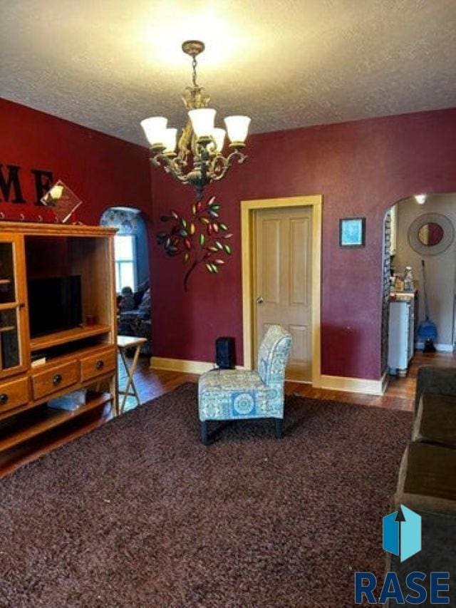 living room featuring a textured ceiling and an inviting chandelier