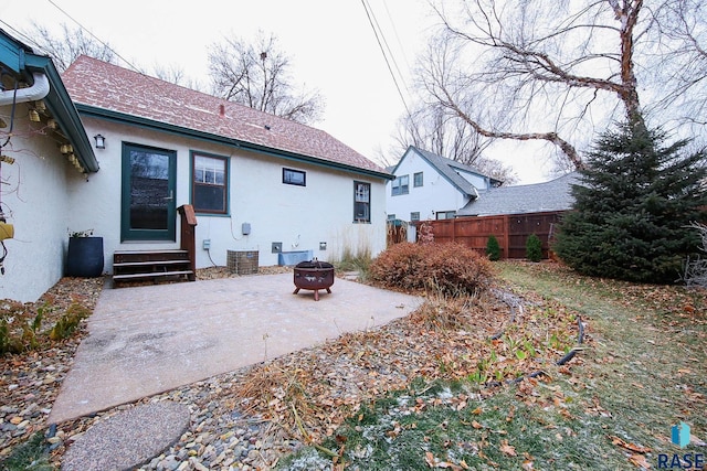 back of property with a patio area and a fire pit