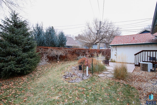 view of yard with central air condition unit and a fire pit