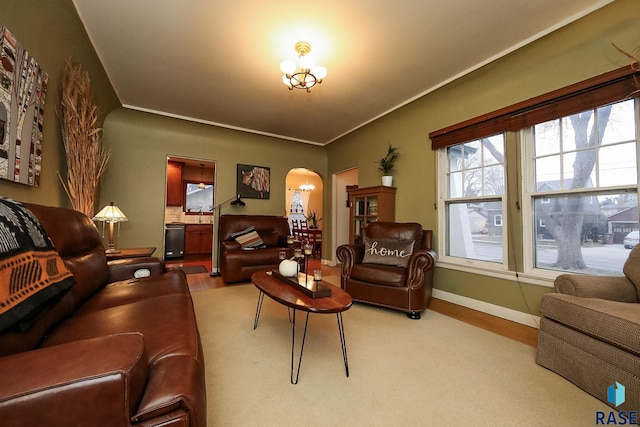 living room featuring a chandelier, crown molding, and hardwood / wood-style flooring