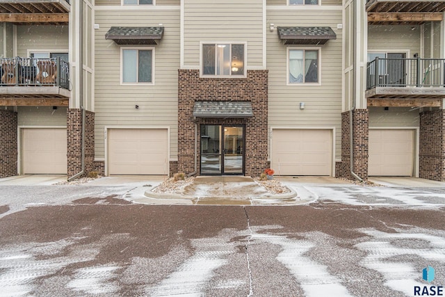 multi unit property featuring a garage and brick siding