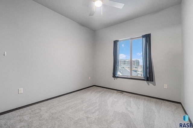 unfurnished room with ceiling fan and carpet