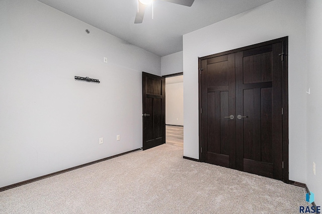 unfurnished bedroom with ceiling fan, light colored carpet, and a closet