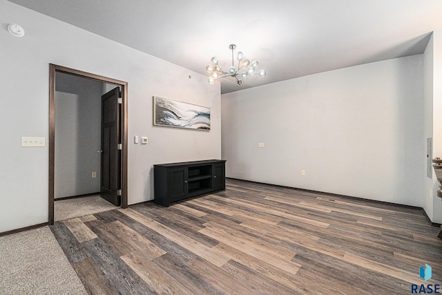 unfurnished room with an inviting chandelier and dark hardwood / wood-style floors