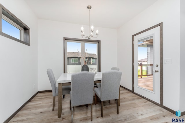 dining area featuring light wood-type flooring and an inviting chandelier