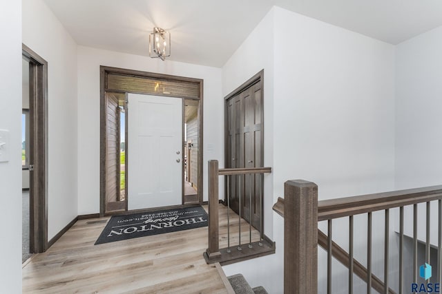 entrance foyer featuring light wood-type flooring and a notable chandelier