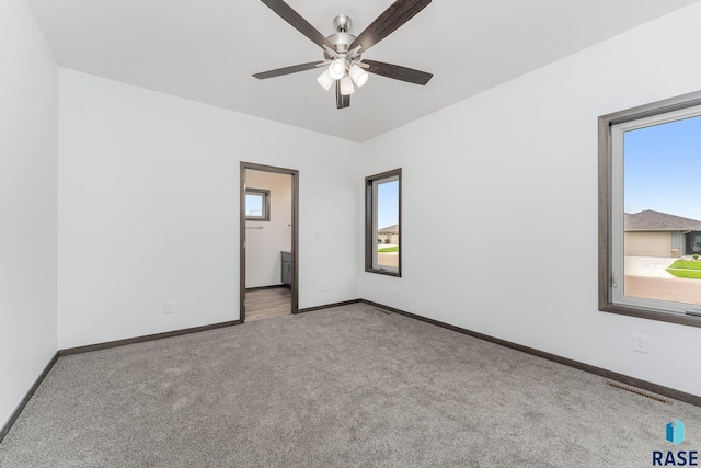 spare room with ceiling fan and light colored carpet