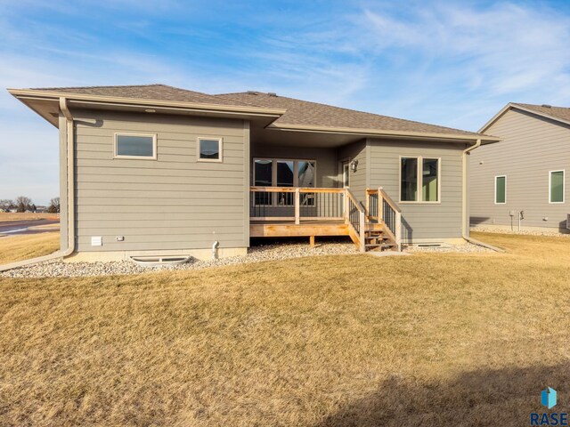 rear view of property featuring a wooden deck and a yard