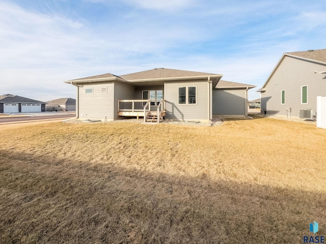 back of house featuring a deck, central AC unit, and a yard