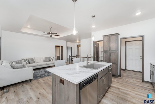 kitchen featuring a center island with sink, ceiling fan, hanging light fixtures, stainless steel dishwasher, and sink