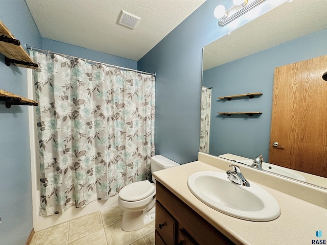 bathroom with toilet, vanity, tile patterned flooring, and a textured ceiling