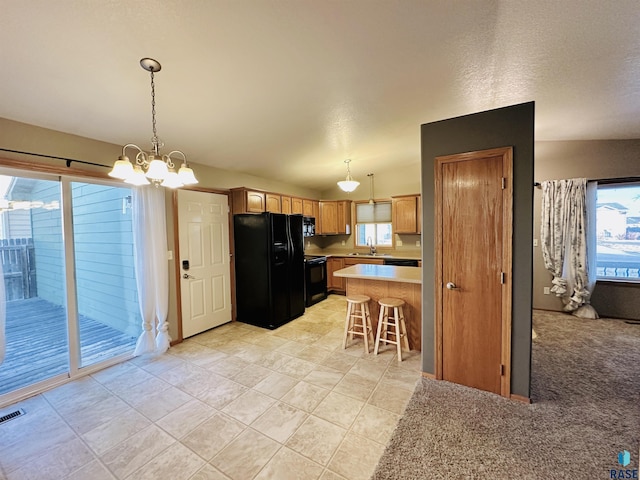 kitchen featuring a kitchen bar, sink, pendant lighting, and black appliances