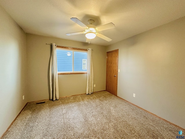 spare room featuring ceiling fan and carpet