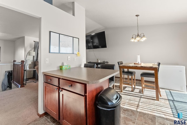 kitchen featuring hanging light fixtures, light carpet, a notable chandelier, and vaulted ceiling