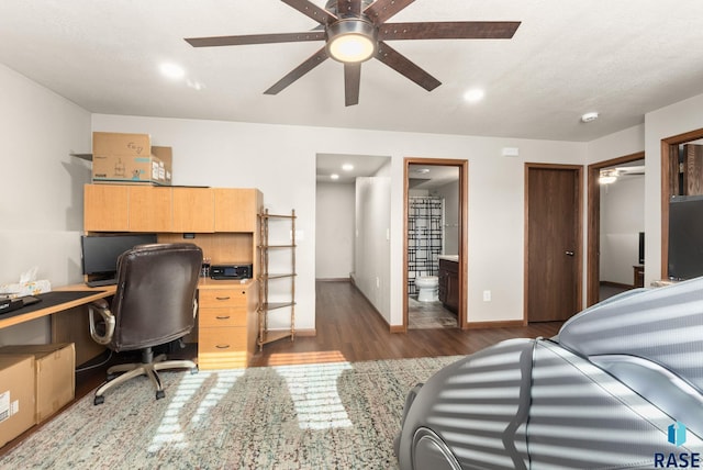 bedroom featuring ceiling fan, dark hardwood / wood-style flooring, and connected bathroom