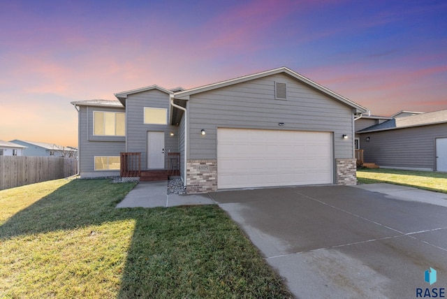 view of front of property with a garage and a yard