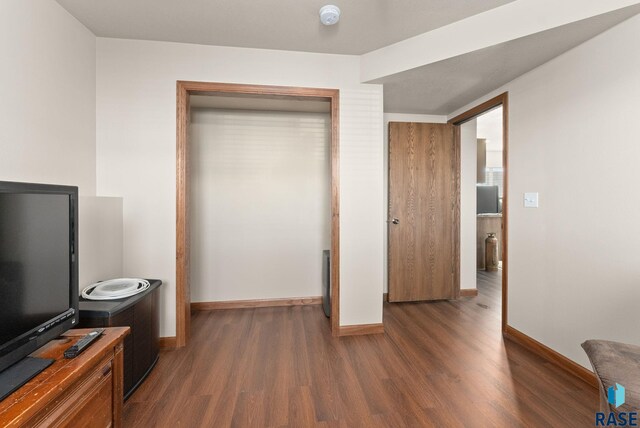 bedroom with dark wood-type flooring and a closet