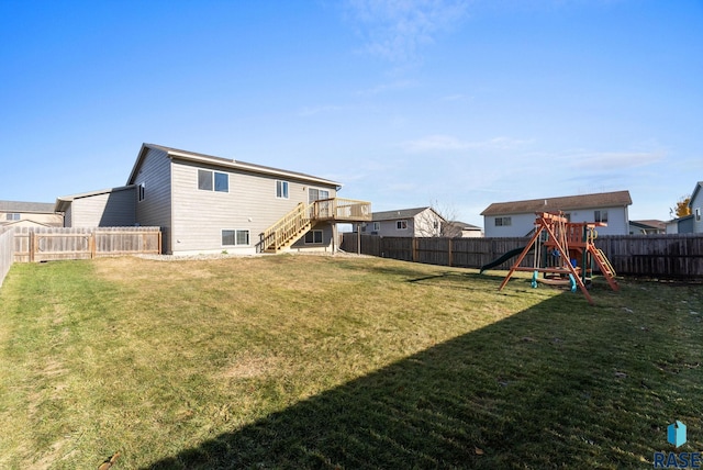 rear view of house featuring a playground and a lawn