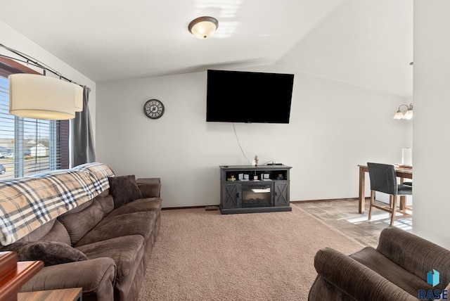 carpeted living room with lofted ceiling and an inviting chandelier