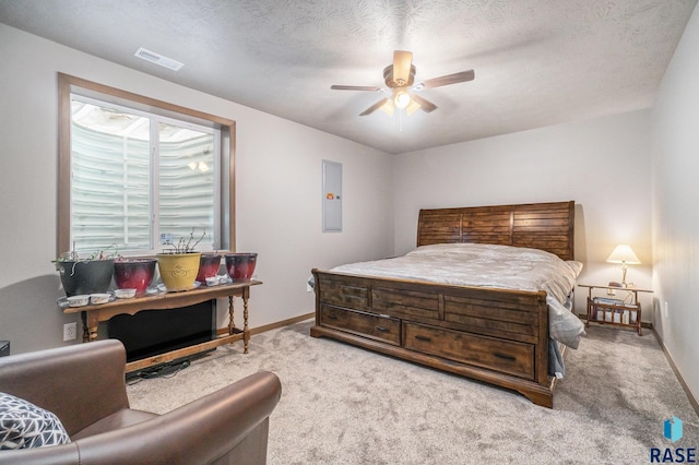 carpeted bedroom featuring ceiling fan, a textured ceiling, and electric panel