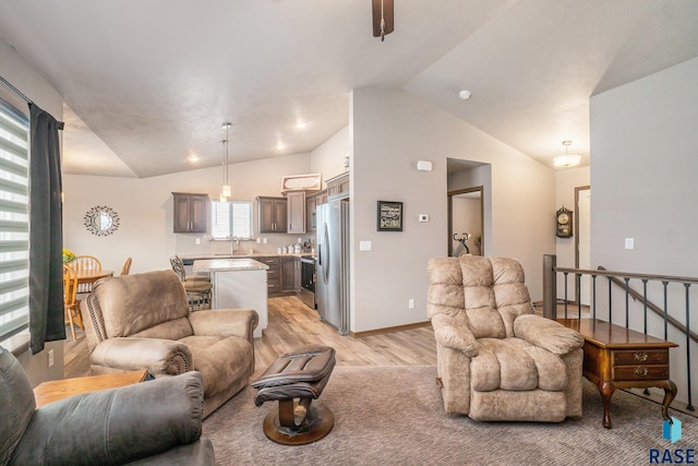 living room featuring vaulted ceiling and light hardwood / wood-style floors