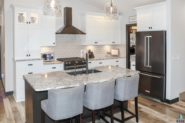 kitchen featuring white cabinetry, high quality appliances, and wall chimney range hood