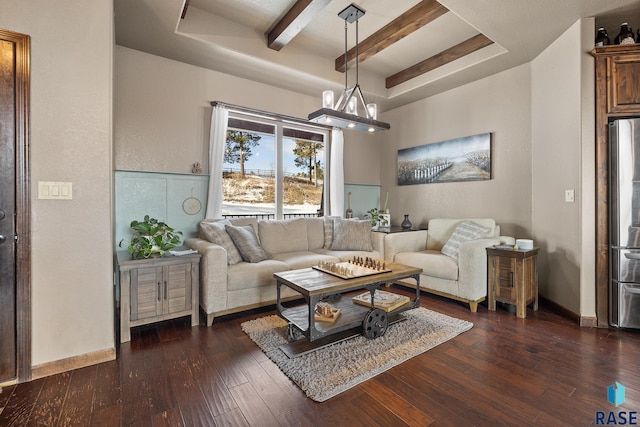 living room with a tray ceiling, dark hardwood / wood-style floors, and a chandelier