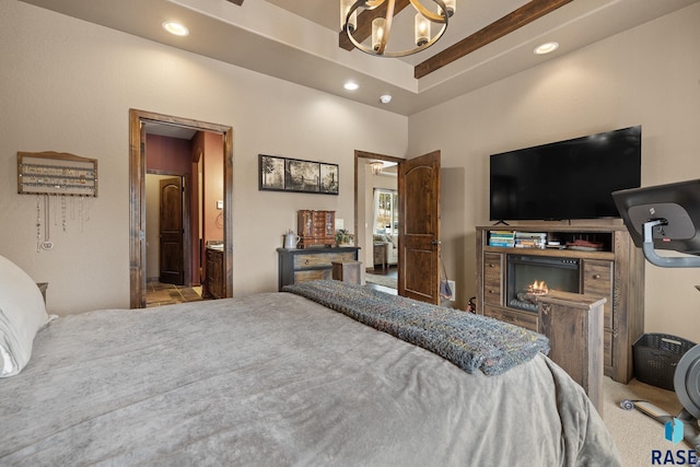 carpeted bedroom featuring a chandelier and ensuite bath