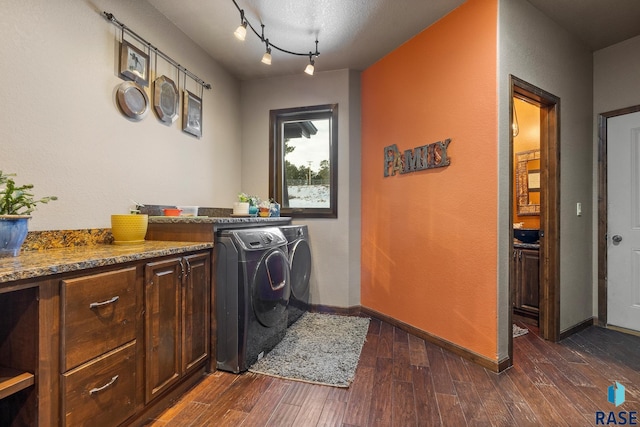 clothes washing area with cabinets, independent washer and dryer, dark hardwood / wood-style flooring, and track lighting