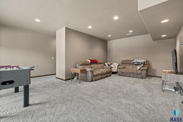 recreation room featuring light colored carpet and a textured ceiling