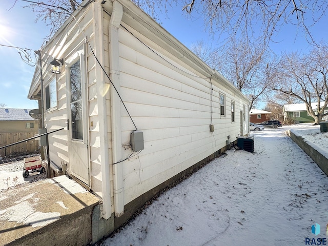 view of snowy exterior featuring central air condition unit