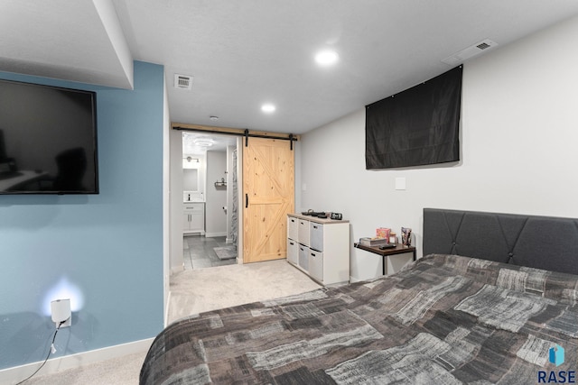 carpeted bedroom featuring a barn door