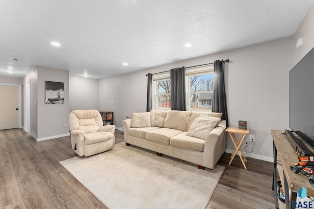 living room featuring wood-type flooring and a textured ceiling