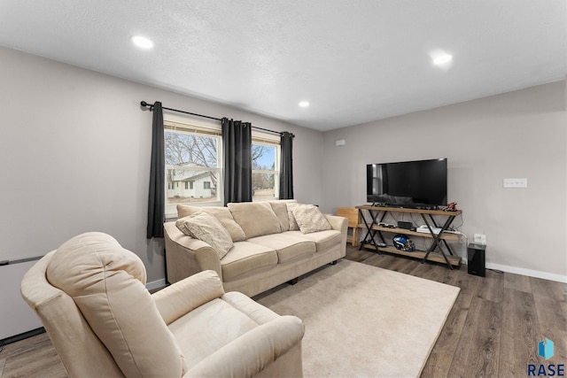 living room featuring dark hardwood / wood-style flooring and a textured ceiling